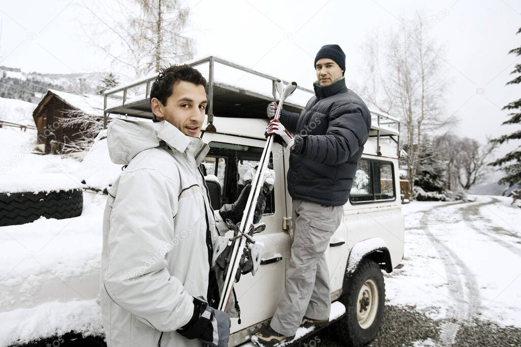 Men taking out skis equipments