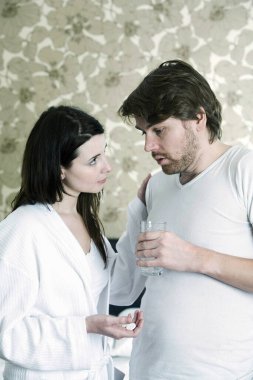 Erkeği ilaç almaya ikna eden bir kadın.