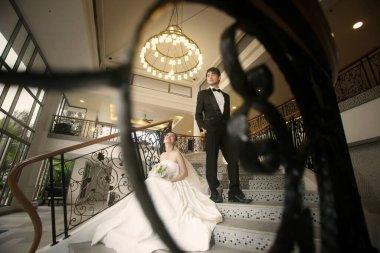 Gelin ve damat merdivenlerde içeride poz veriyorlar.