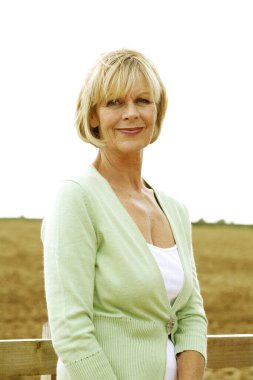 Kıdemli kadın kameraya gülümsüyor.