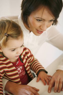 Anne ve kızı dizüstü bilgisayar kullanıyor.