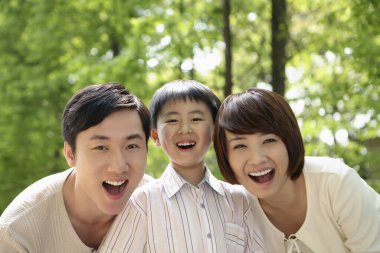 Oğlan ve ailesi parkta eğleniyor.