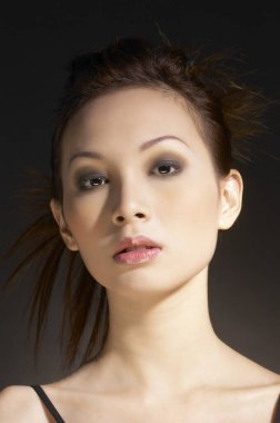 Makyajlı ve saç kesimli çekici bir kadının stüdyo fotoğrafı.