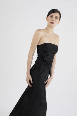 Siyah yemek elbisesi giymiş bir bayanın stüdyo fotoğrafı.