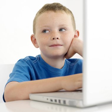 Çocuk dizüstü bilgisayar kullanırken yüzünü çeviriyor