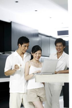 Mutfakta dizüstü bilgisayarla gülen arkadaşlar