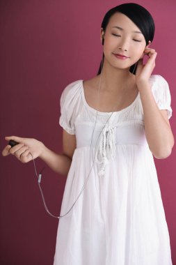 Taşınabilir MP3 çalarda müzik dinleyen kadın, gözlerini kapatıyor