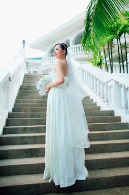 Merdivenlerde duran buketli gelin.