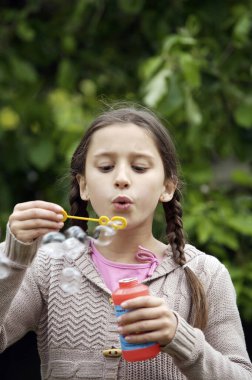 Kız değnekle kabarcıklar çıkarıyor