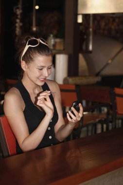 Kadın cep bilgisayarından mesaj atıyor.