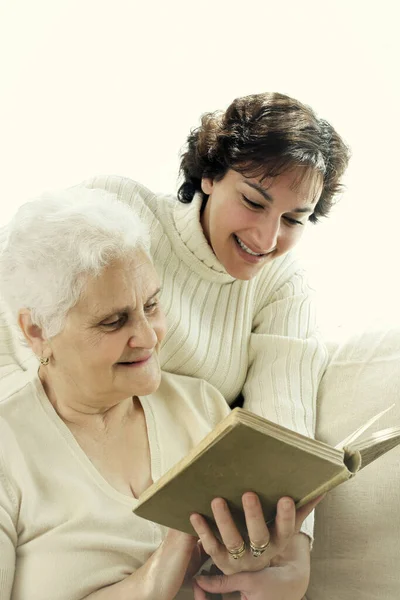 Yaşlı Annesiyle Kitap Paylaşan Bir Kadın — Stok fotoğraf