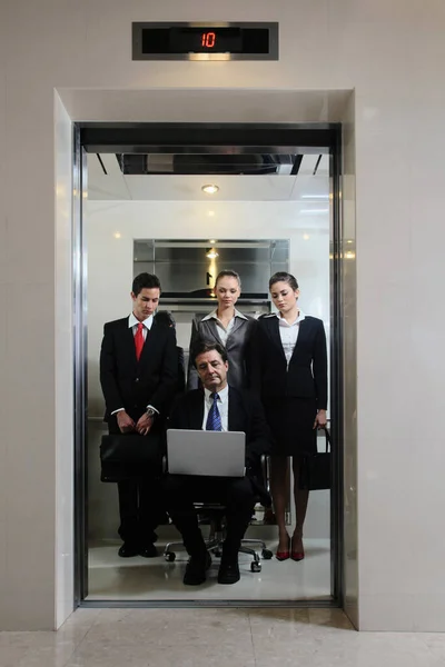 Ділові Люди Спостерігають Бізнесмен Сидить Офісному Стільці Використовує Ноутбук Ліфті — стокове фото