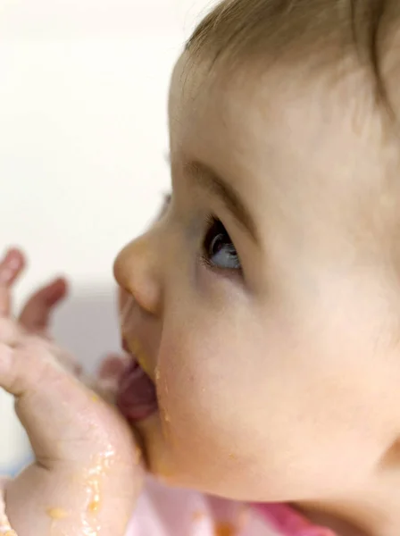 顔に食べ物と赤ちゃんの女の子 — ストック写真