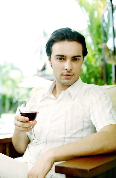 Homem Segurando Copo Vinho Tinto Enquanto Olha Para Câmera — Fotografia de Stock