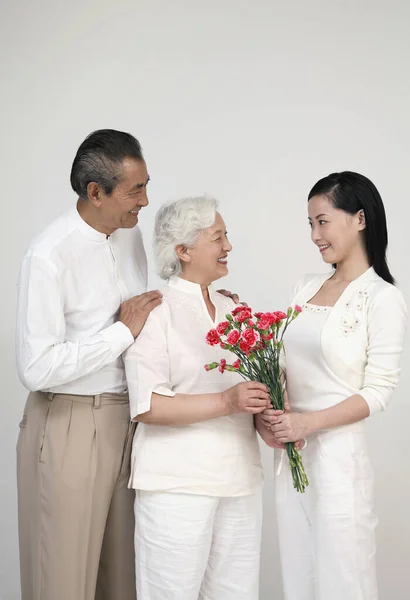 Γυναίκα Δίνει Στην Ηλικιωμένη Ένα Μπουκέτο Λουλούδια Ηλικιωμένος Άντρας Χαμογελάει — Φωτογραφία Αρχείου