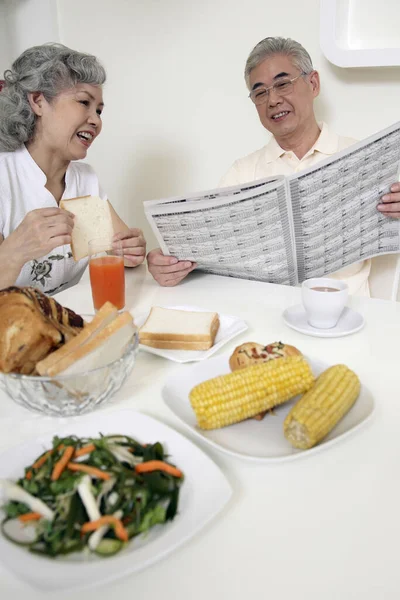 Senior Man Senior Woman Reading Newspaper While Having Breakfast Together — Stock Photo, Image