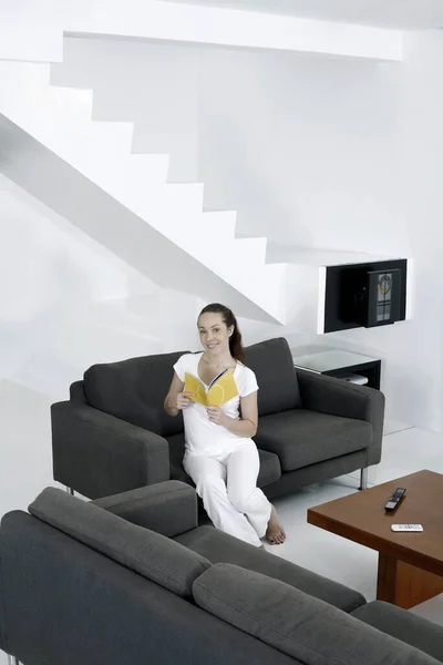 Mujer Sentada Sofá Leyendo Libro — Foto de Stock