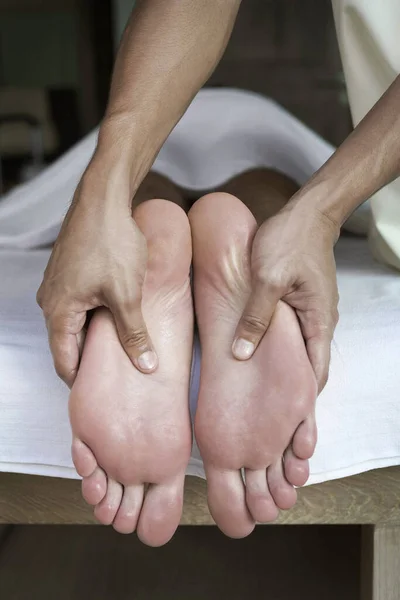 マッサージセラピストがお客様の足をマッサージし — ストック写真