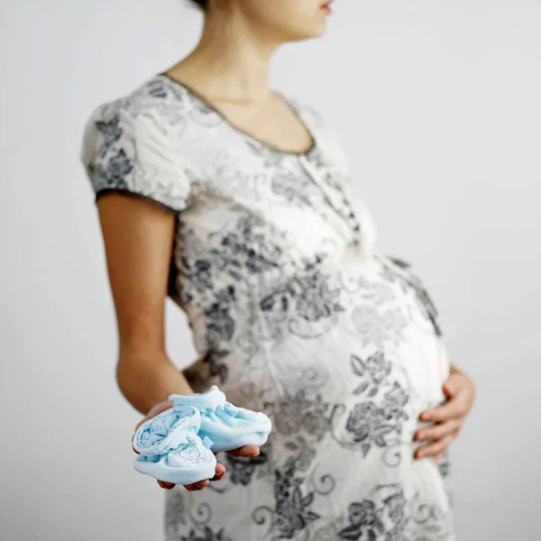 Zwangere Vrouw Met Een Paar Lichtblauwe Baby Laarzen — Stockfoto