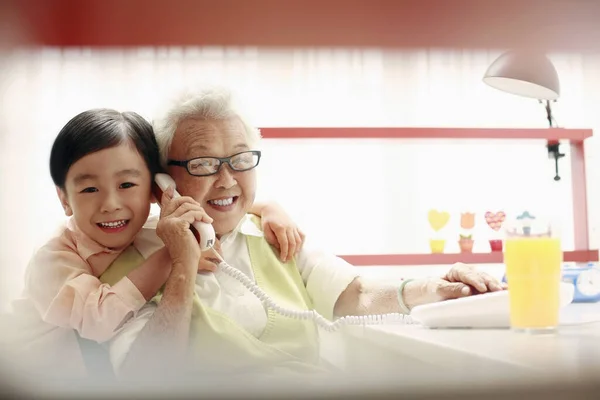 Chlapec Objímající Starší Ženu Zatímco Ona Mluví Telefonu — Stock fotografie