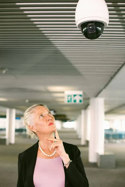 Businesswoman looking at security camera in airport lounge