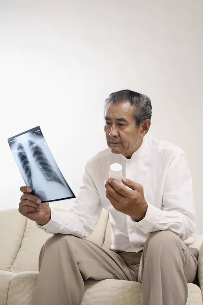 Старший Мужчина Держит Рентген Бутылку Таблеток — стоковое фото
