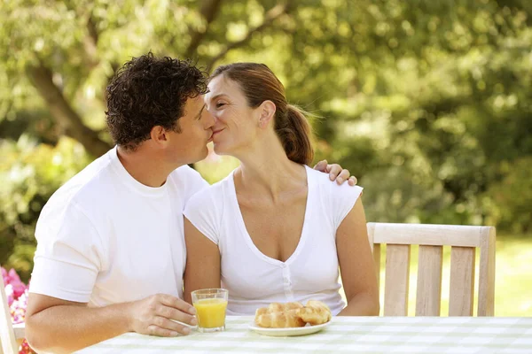 Couple sitting at the picnic table kissing