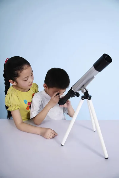 Junge Blickt Durch Teleskop Während Mädchen Auf Ihre Umdrehung Wartet — Stockfoto