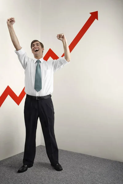 Businessman shaking fist in victory, arrow sign going up