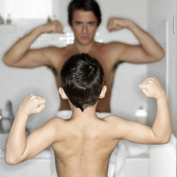 父亲和儿子炫耀他们的肌肉手臂 — 图库照片