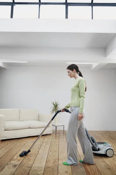 Woman vacuuming the floor