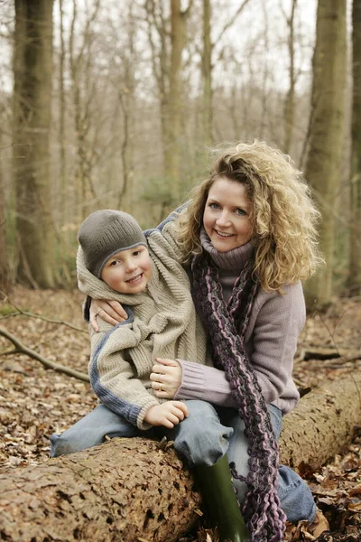 Moeder Knuffelende Zoon Zittend Een Boomstam — Stockfoto