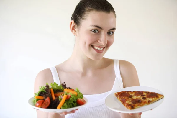 Woman holding pizza and salad