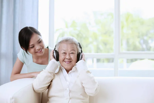 Senior Vrouw Luistert Naar Muziek Hoofdtelefoon Vrouw Kijkt Naar Haar — Stockfoto