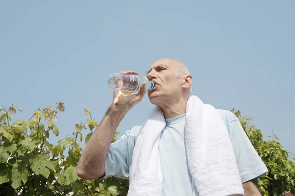 Senior Man Met Handdoek Zijn Nek Drinken Van Flessenwater — Stockfoto