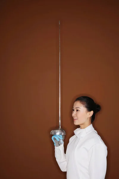 Woman in fencing suit with fencing foil