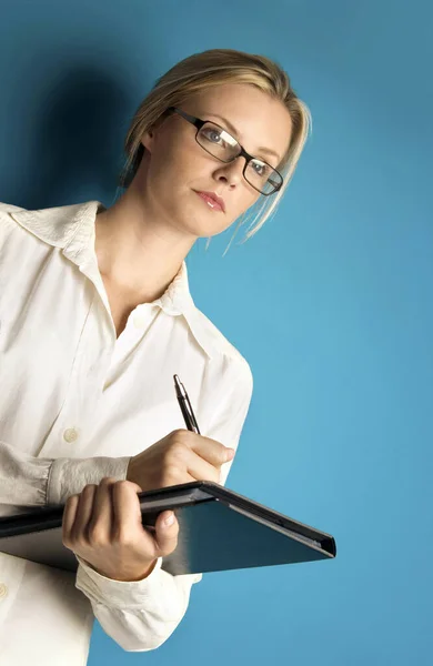 Vrouw Met Bril Schrijft Stockfoto