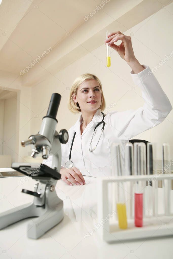 Woman examining liquid in test tube