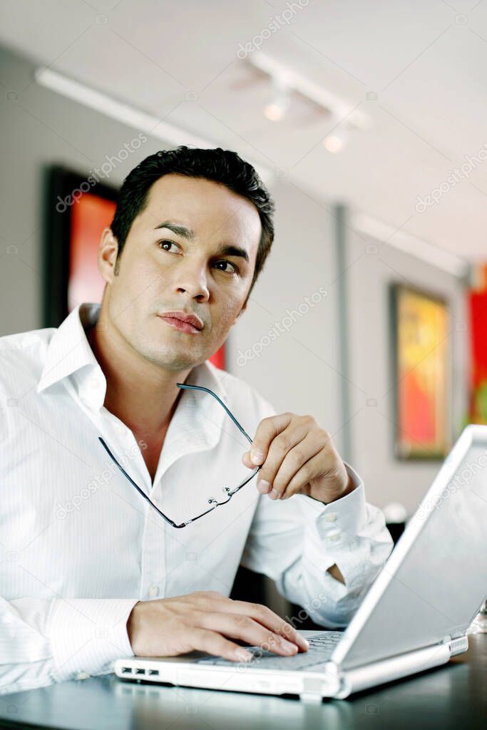 Man thinking while using laptop
