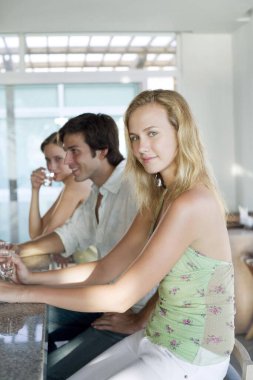 Man and two women sitting at the bar counter clipart
