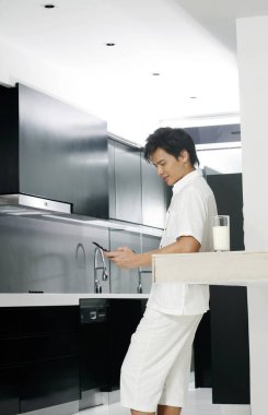 Adam mutfakta bir telefon görüşmesi yapıyor.