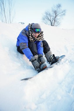 Adam snowboard yapmaya hazırlanıyor.
