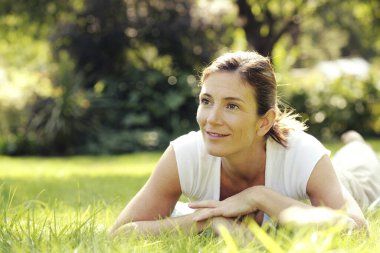 Sahada ileri doğru uzanan kadın gülümsüyor.