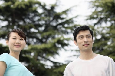 Kadın ve erkek başka tarafa bakarken gülümsüyor.