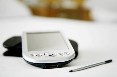 Yatağın üstünde cep telefonu var.