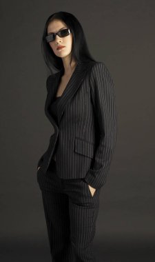 Ofiste güneş gözlüğü takan bir bayanın stüdyo fotoğrafı.