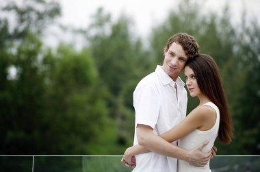 Birbirlerine sarılırken gülümseyen çiftler.