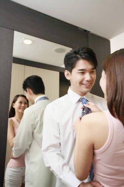 Kadın, erkeğin işe hazırlanmasına yardım ediyor.