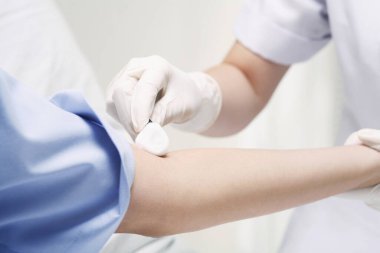 İğneden önce hastanın kolunu temizleyen doktor.