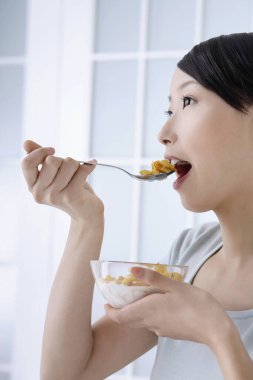 Kahvaltılık gevreğin tadını çıkaran kadın.